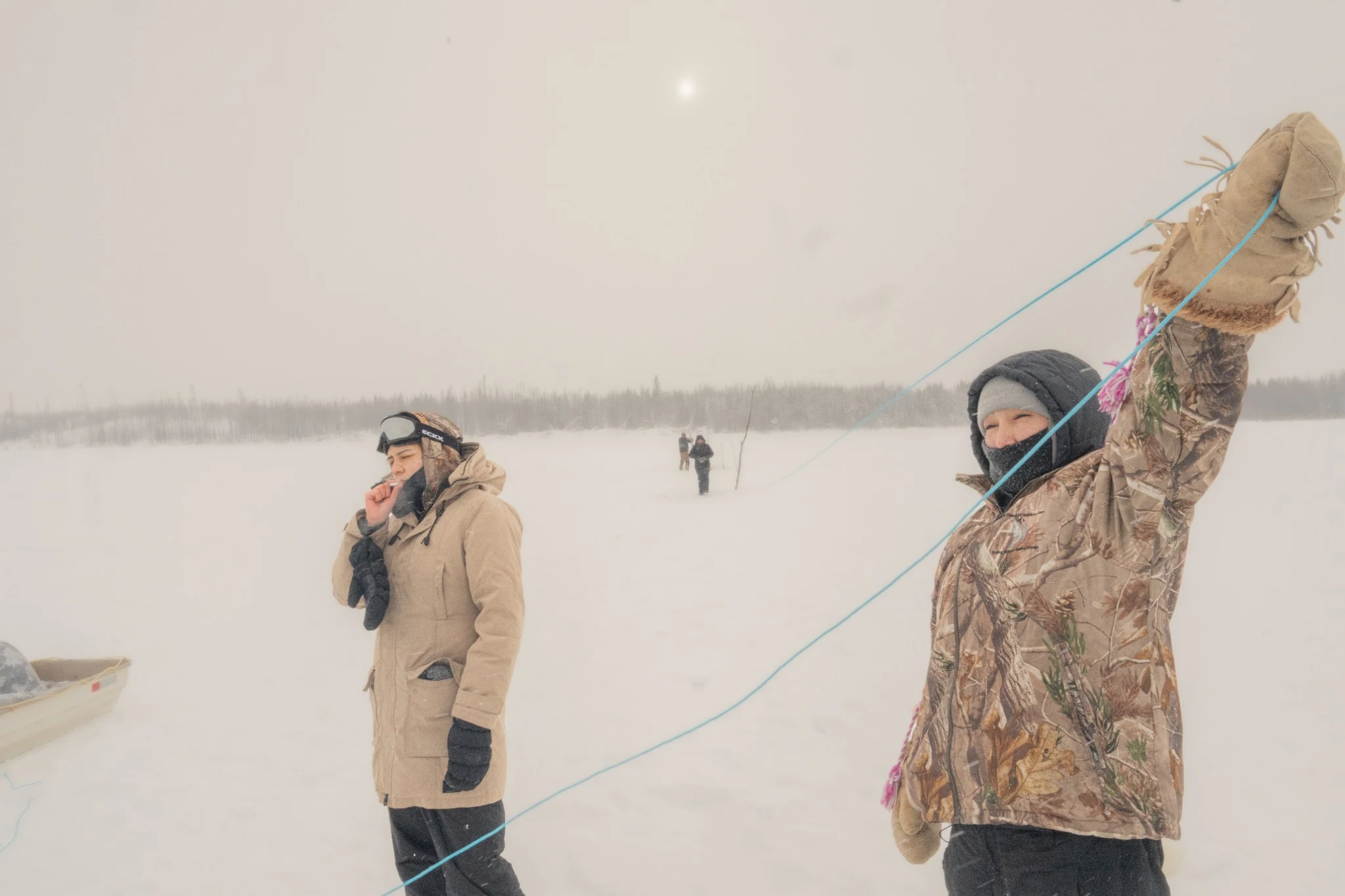 People handling a line on a snowy lake